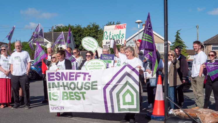 Group of people outside holding a banner stating ESNEFT: In-house is best.