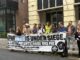 A large group of people hold a Unite the union banner in support of the NHS