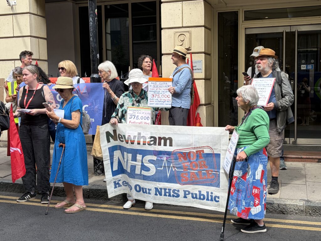 A group of people stand holding a Newham Keep Our NHS Public banner